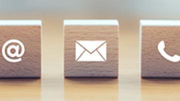 Three wooden blocks, one with an email icon, one with an envelop icon and one with a telephone icon